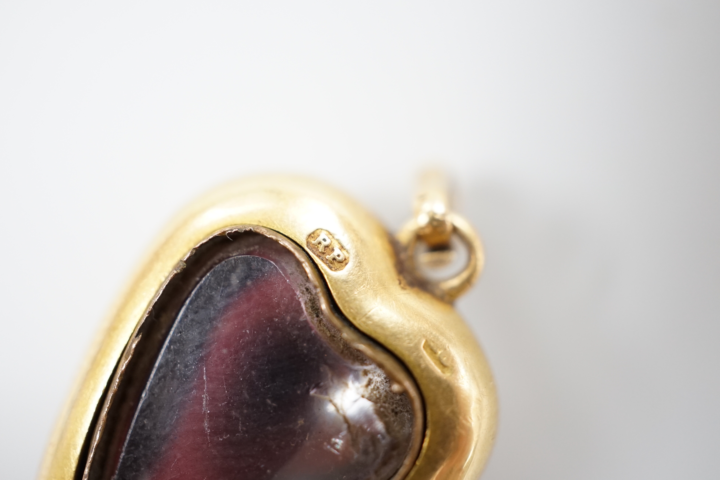 A late Victorian yellow metal (stamped 18) and cabochon garnet set heart shaped pendant, with glazed back, 22mm, gross weight 5.7 grams.